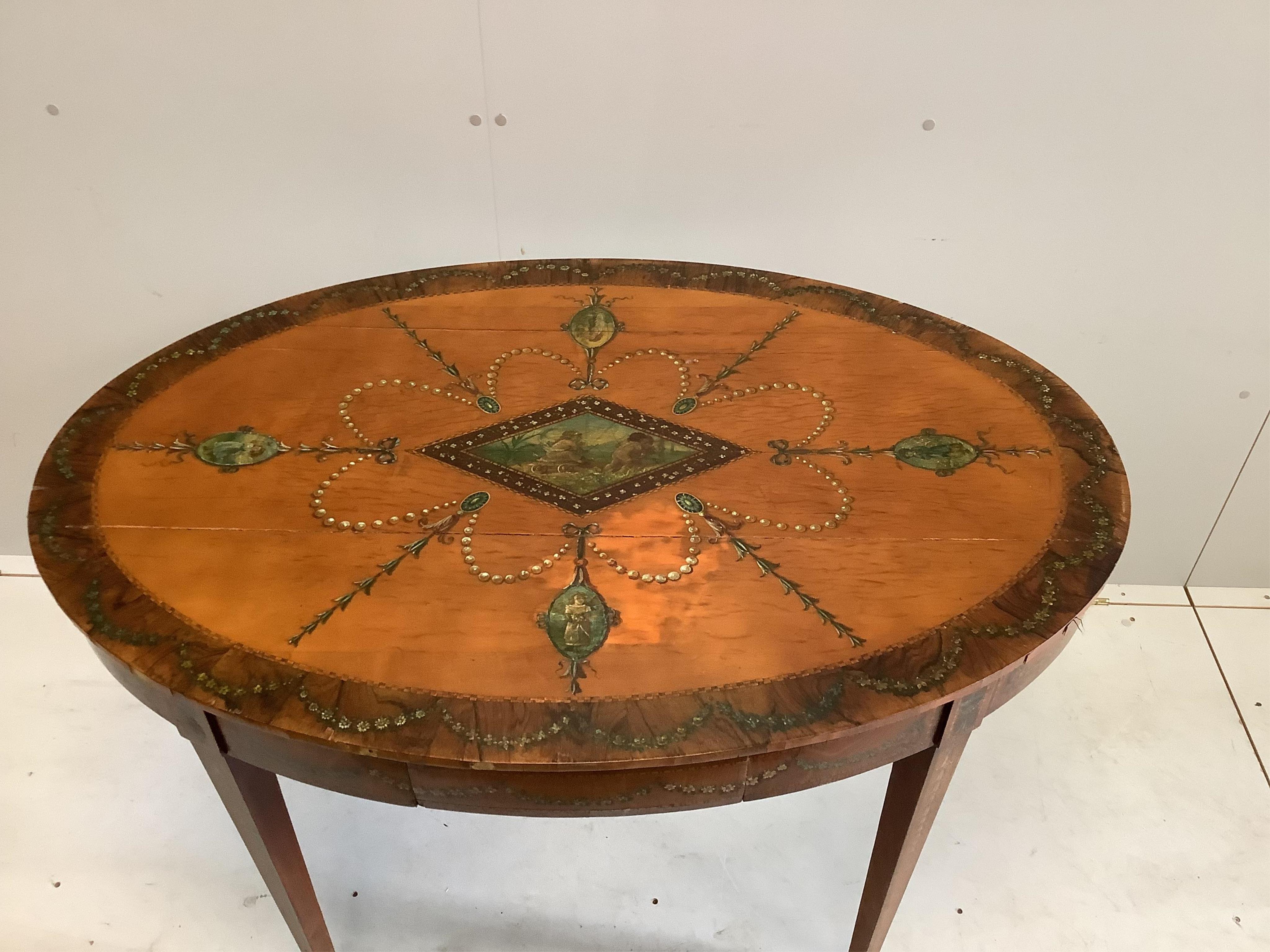 An Edwardian Sheraton revival painted satinwood oval centre table, width 117cm, depth 80cm, height 74cm. Condition - poor